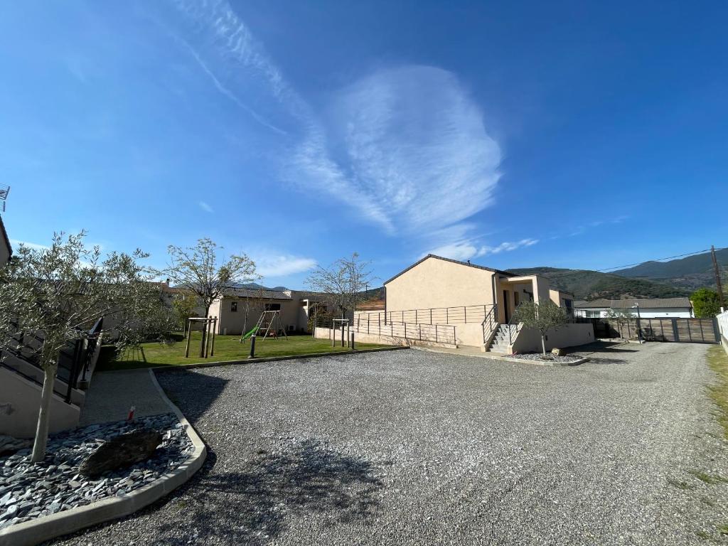 a driveway in front of a house with a building at CLOS ARIA NOVA in Lucciana