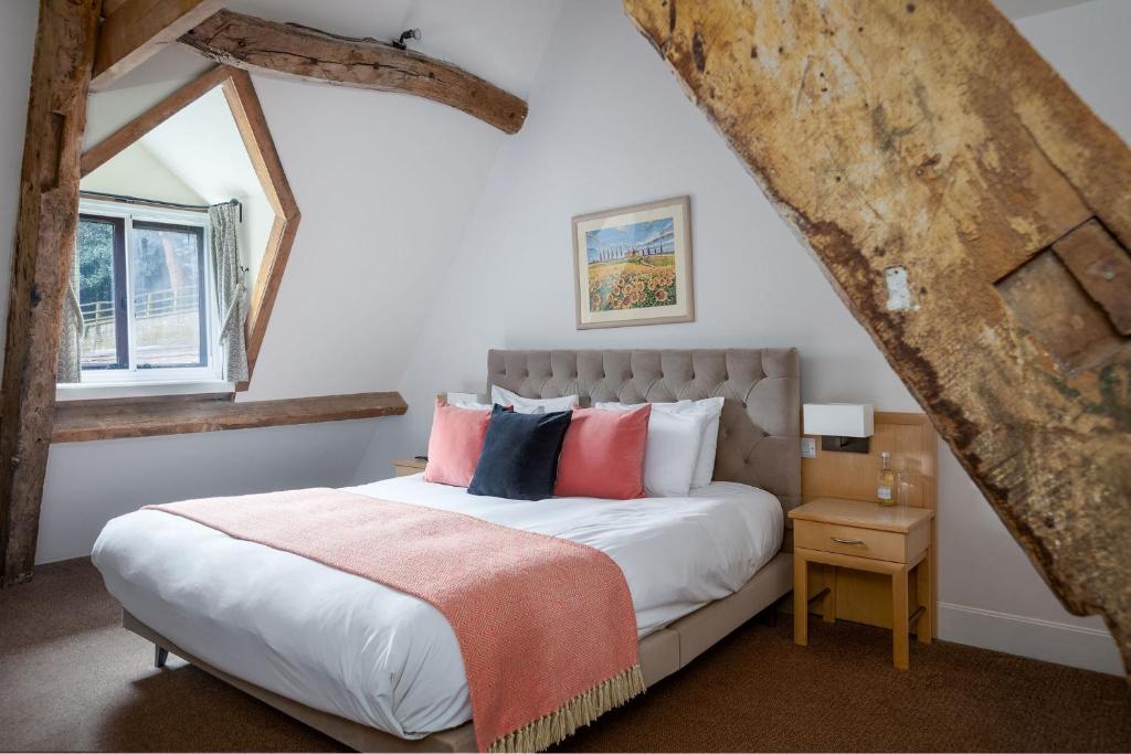 a bedroom with a large bed and a window at Egypt Mill Hotel and Restaurant in Nailsworth
