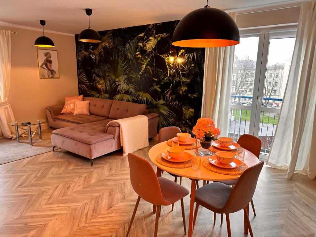 a living room with a table and a couch at HUDSON APARTAMENT CENTRUM in Koszalin