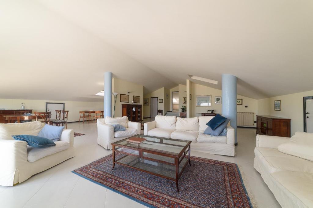 Sala de estar con sofás blancos y mesa de centro en Villa Pescara, en Pescara
