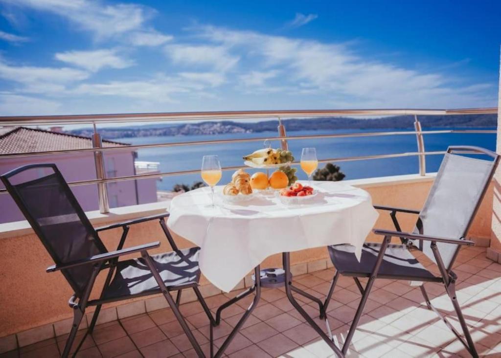 een tafel met een schaal fruit en wijnglazen op een balkon bij Lovely 1-bedroom APT w/ seaview + free parking in Trogir