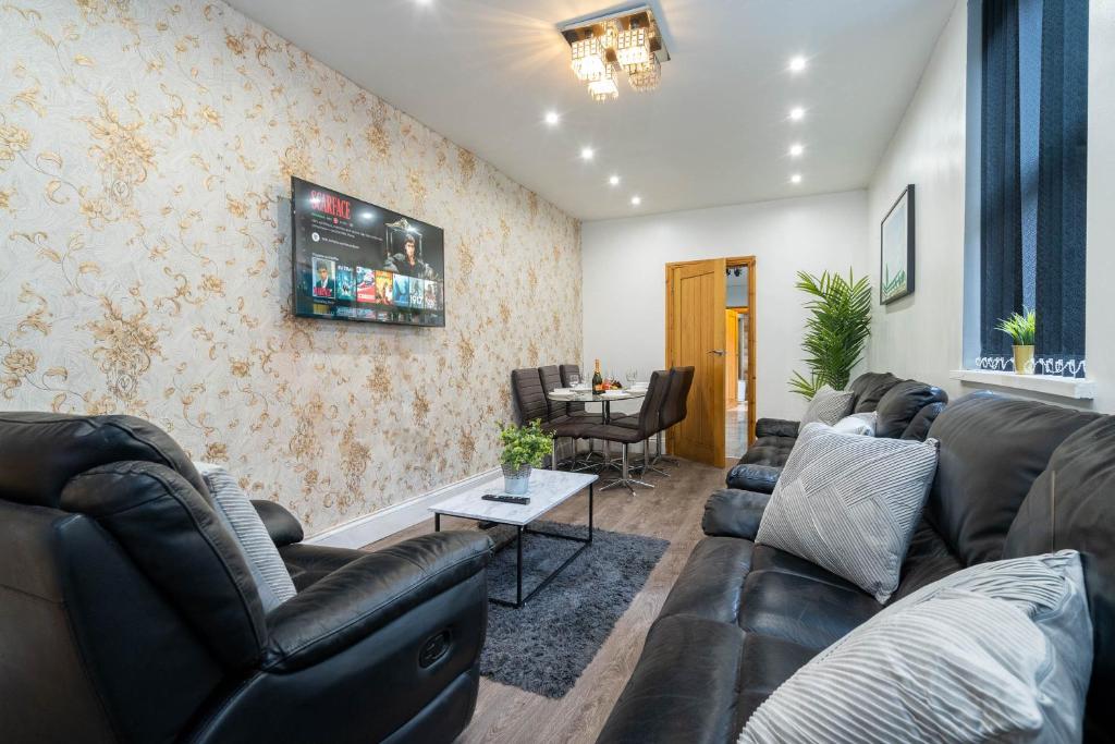 a living room with leather couches and a table at Large 7 Bedroom Townhouse with Parking - WIFI & Netflix - Sleeps 16 - 568P in Birmingham
