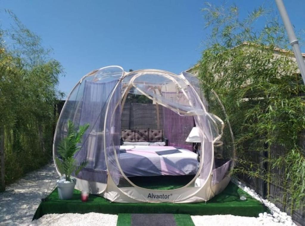 Bett in einem Kuppelzelt im Garten in der Unterkunft Le Refuge Zen et bien-être bulle in Montpouillan