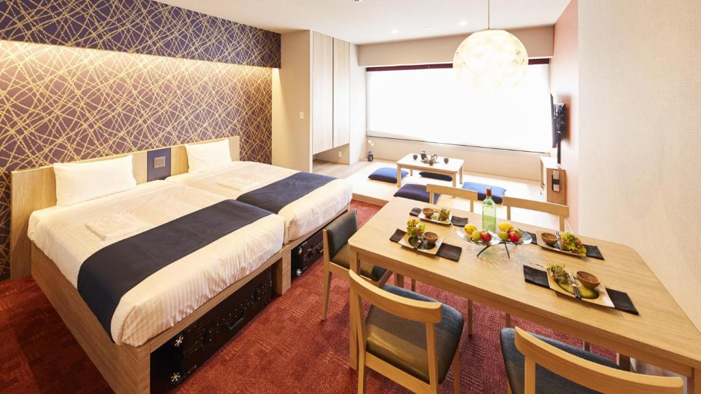 Pokój hotelowy z łóżkiem, biurkiem i stołem w obiekcie MONday Apart 日本橋水天宮前 w Tokio