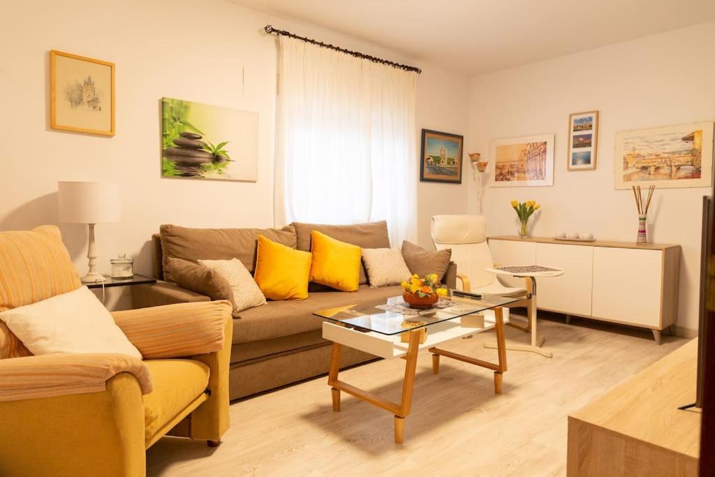 ein Wohnzimmer mit einem Sofa und einem Tisch in der Unterkunft El Patio de la Viña by Gades Gestión in Cádiz