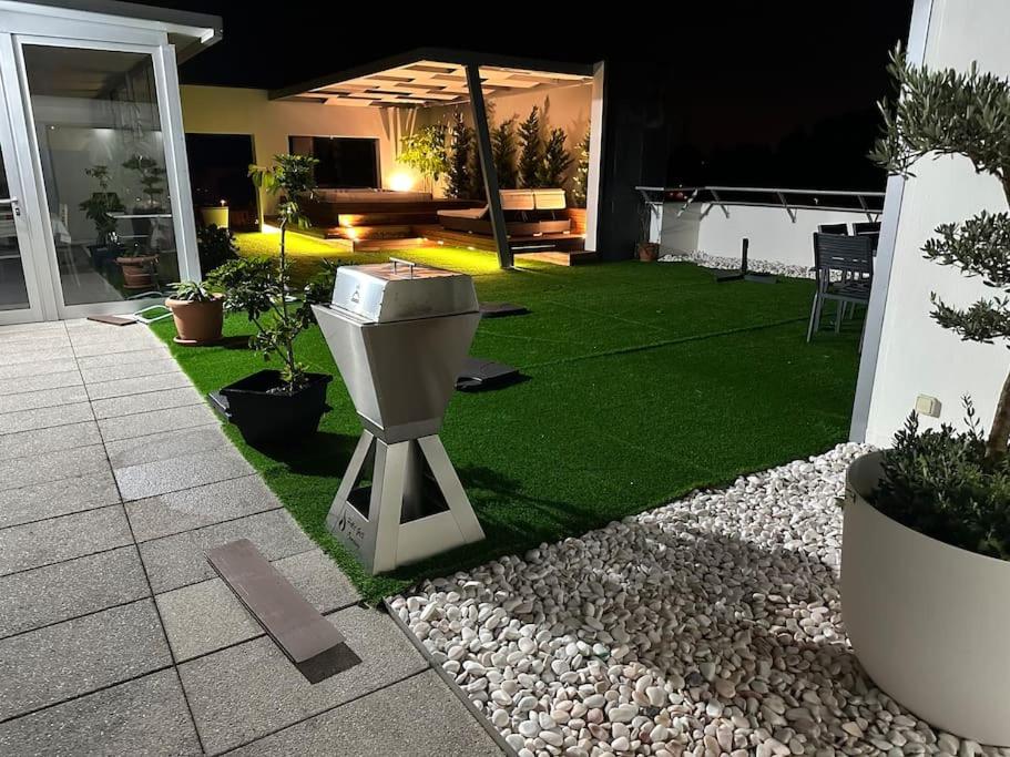a garden with a trash can on the grass at Penthouse com Jacuzzi in Coimbra