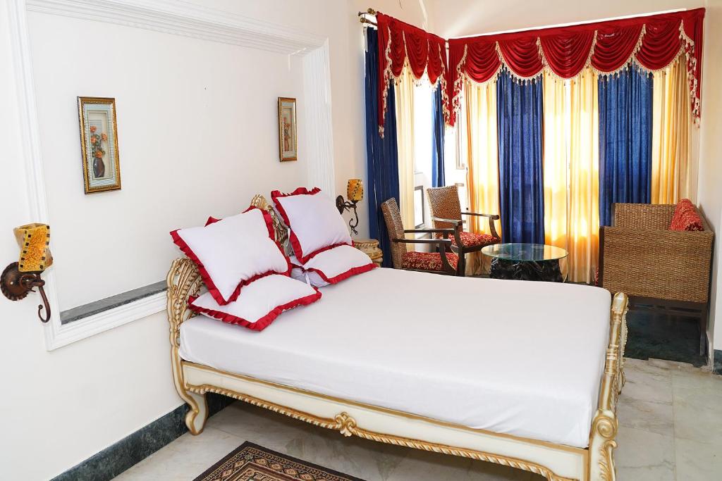 een slaapkamer met een bed met rode kussens erop bij FabHotel Prime Indeedcare Resort Bakkhali in Bakkhali