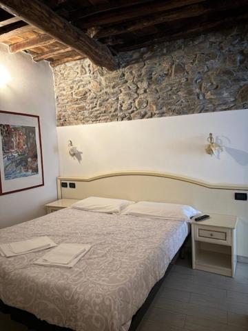 a bedroom with a bed and a stone wall at Locanda Ca Dei Duxi in Riomaggiore