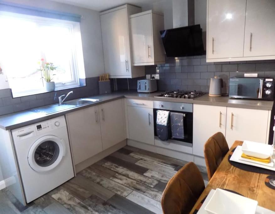 a kitchen with a sink and a washing machine at Modern 3 Bed - Lincoln - Parking in Lincoln