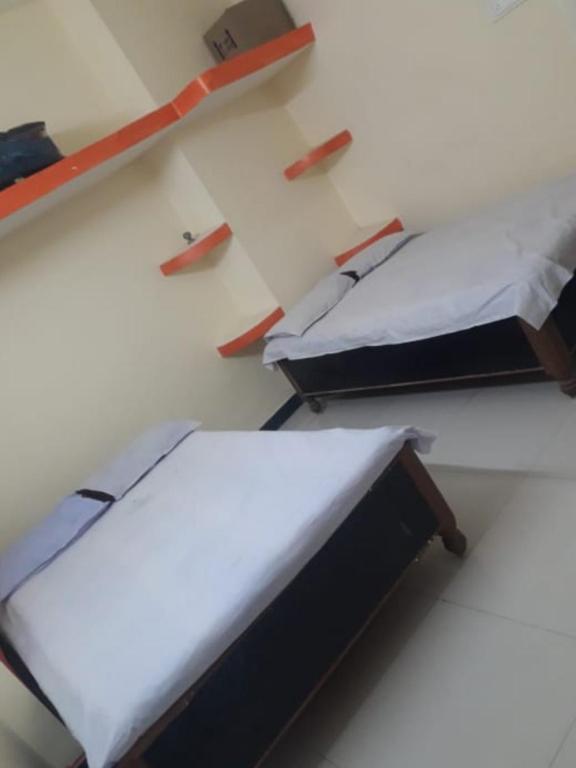 twee bedden in een kamer met bij Atithi niwas in Ratanpur