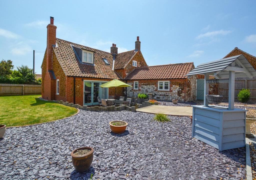 a house with a garden and a patio at Top End Cottage 6 in Ringstead