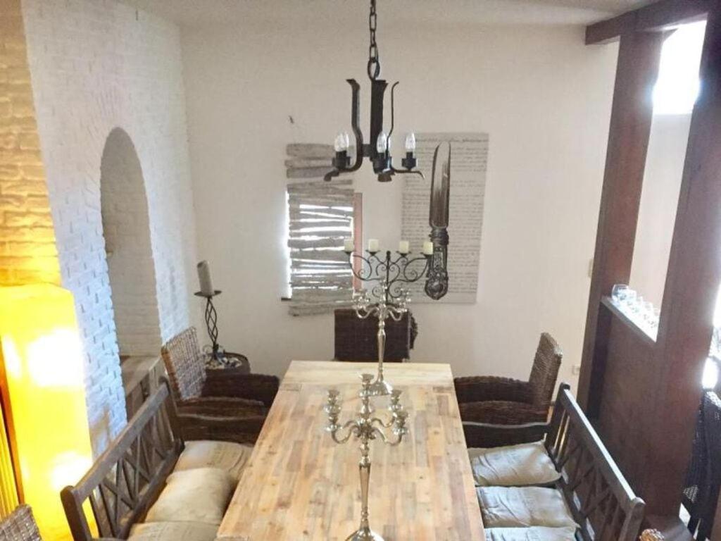 une salle à manger avec une table en bois et un lustre dans l'établissement Nice apartment in Brakel, à Brakel