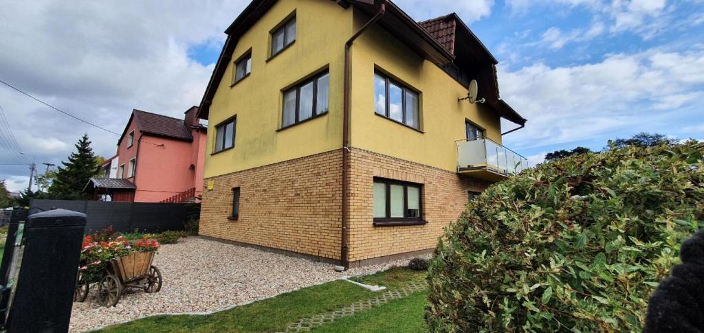 a yellow house with a brick at Ferienwohnung in arnowska mit Grill und Garten in Żarnowska
