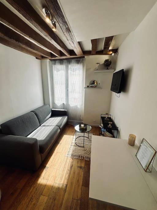 a living room with a couch and a table at Appartement cosy en plein cœur de Paris in Paris