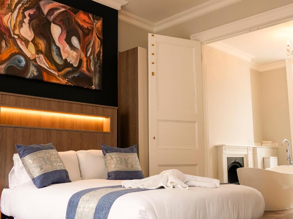 a bedroom with a bed with a painting on the wall at Imperial York Street Apartments in London