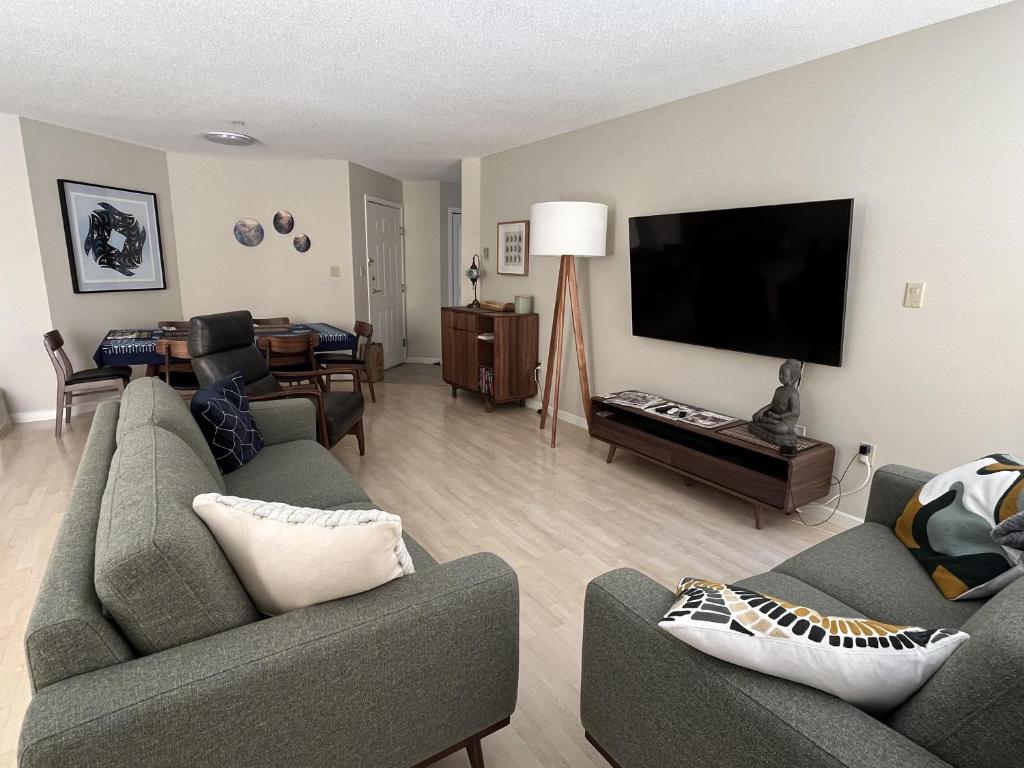 a living room with two couches and a flat screen tv at Harbour Retreat in Victoria