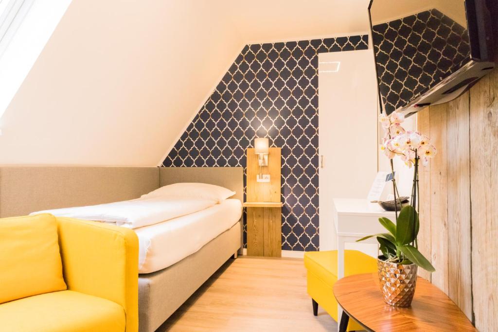 1 dormitorio con cama, sofá y mesa en Hus Mattgoot - private Einzelzimmer im DG und 1 OG, en Ording