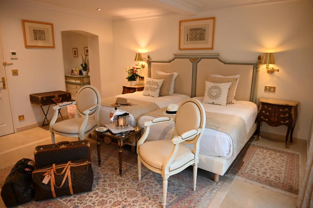 a bedroom with two beds and a table and chairs at Hôtel La Villa Eugene in Épernay