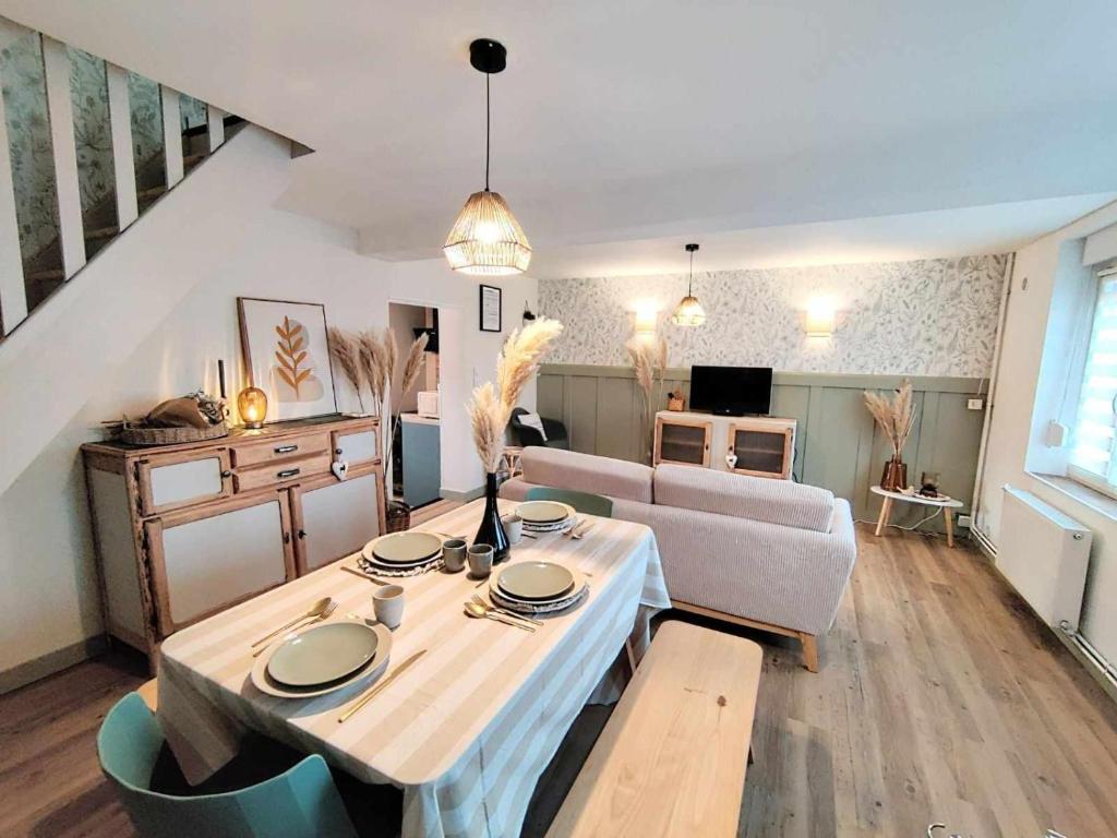 ein Wohnzimmer mit einem Tisch und einem Sofa in der Unterkunft La petite Flânerie in Mondrepuis