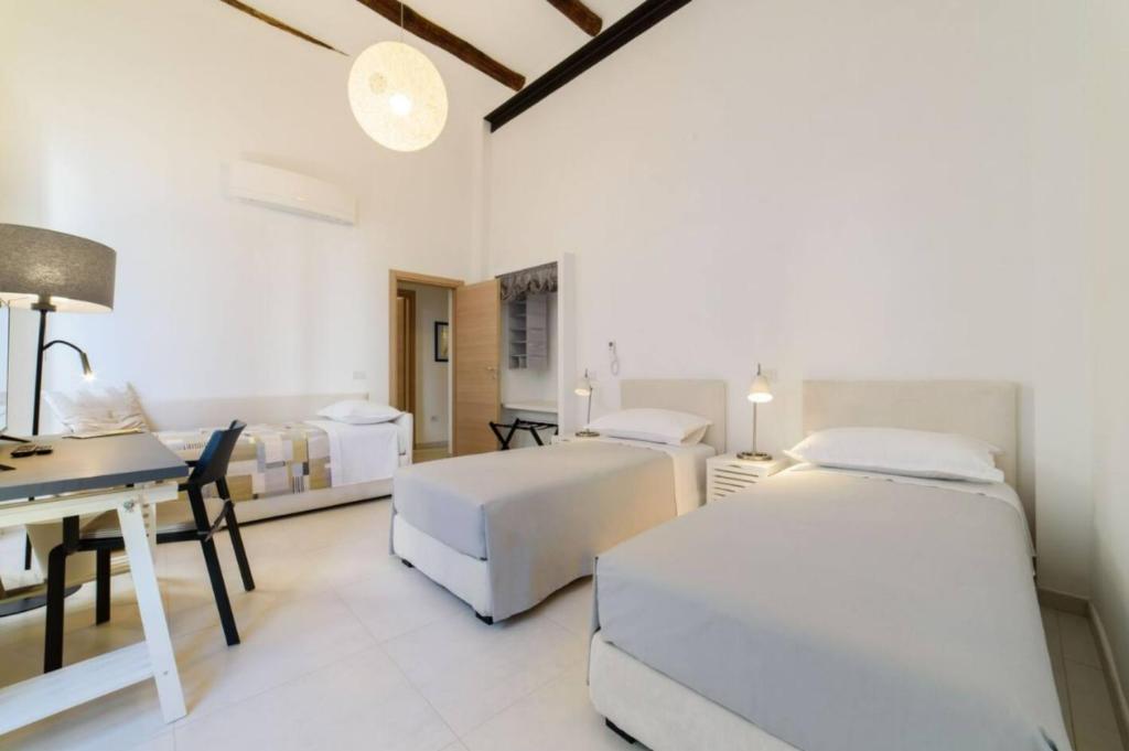 - une chambre avec 2 lits, un bureau et une table dans l'établissement luxury and comfort in historic Salerno, à Salerne