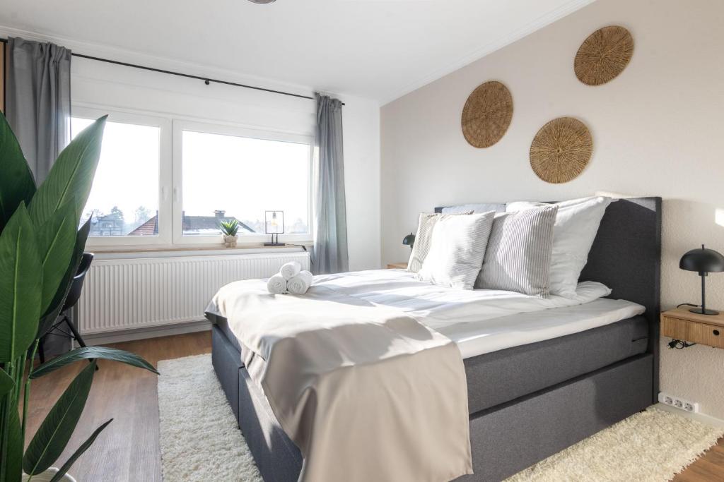 Schlafzimmer mit einem Bett mit weißer Bettwäsche und einem Fenster in der Unterkunft Stilvolle 3-Zimmer Apartments I home2share in Lengerich