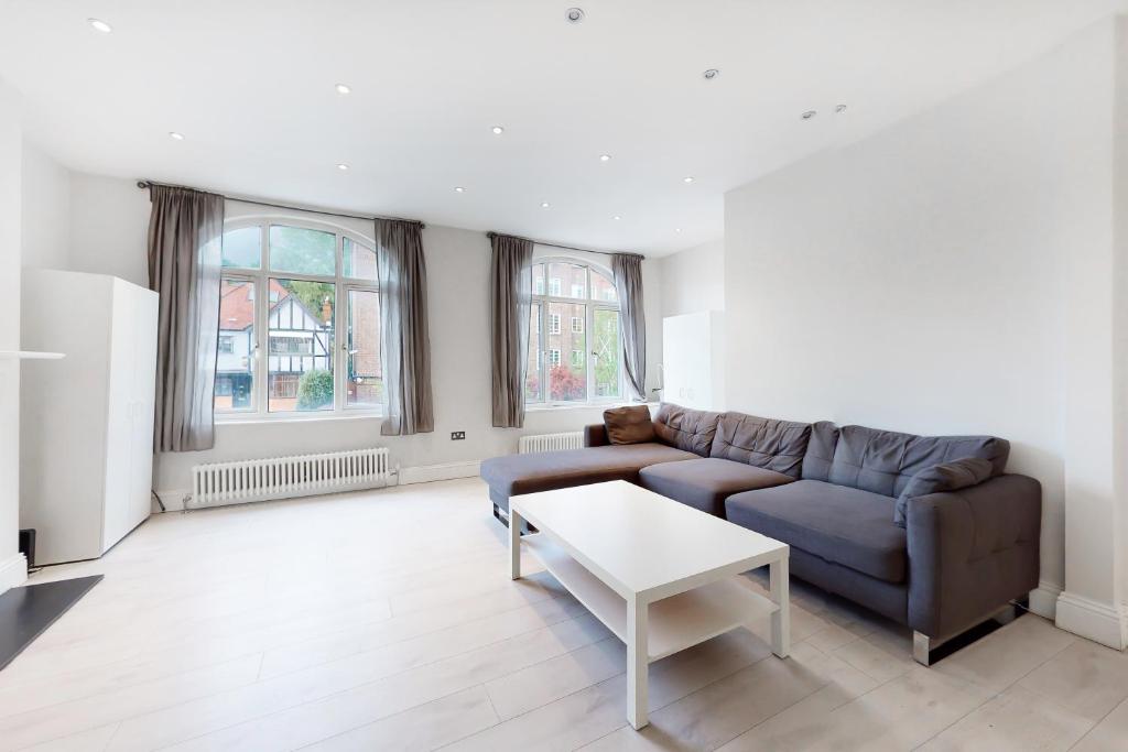 a living room with a couch and a table at Modern 3 Bed Apartment in Hampstead in London