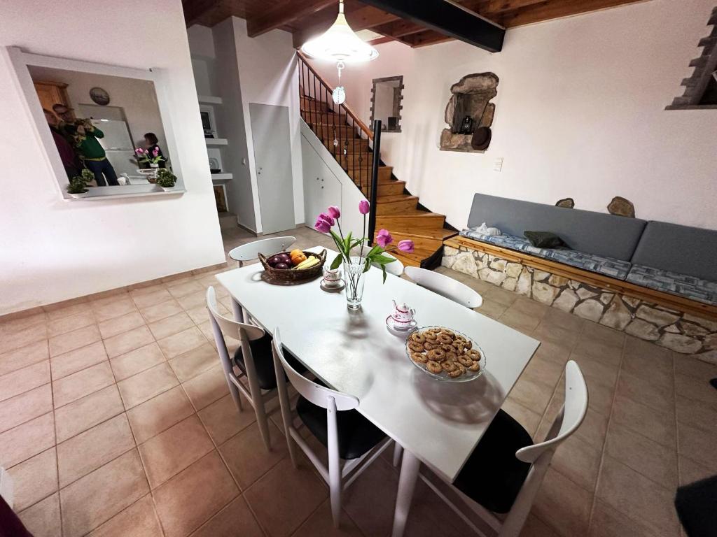 uma mesa branca e cadeiras num quarto com uma escada em Tolis House em Corfu Town