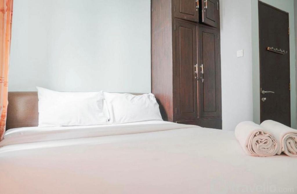 ein weißes Bett mit zwei Handtüchern darüber in der Unterkunft casablanca 1 in Jakarta