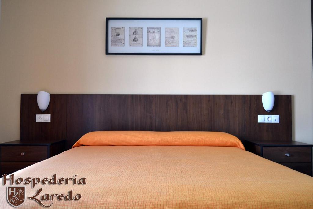 1 dormitorio con 1 cama con una foto en la pared en Hospedería Laredo, en La Carlota
