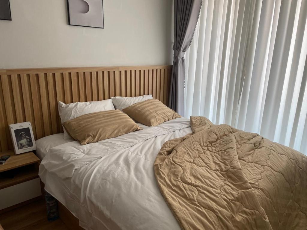 1 cama no hecha en un dormitorio junto a una ventana en Charlotte Boutique - Căn hộ cao cấp cách biển chỉ 3p đi bộ en Phú An