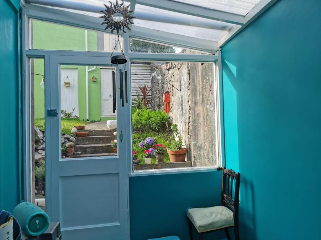 Habitación con puerta azul y ventana en Freedom Park Villa room 3 en Plymouth