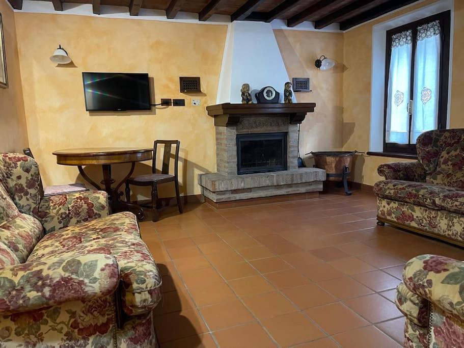 a living room with a couch and a fireplace at La Cassina: accogliente appartamento in campagna in Spilamberto