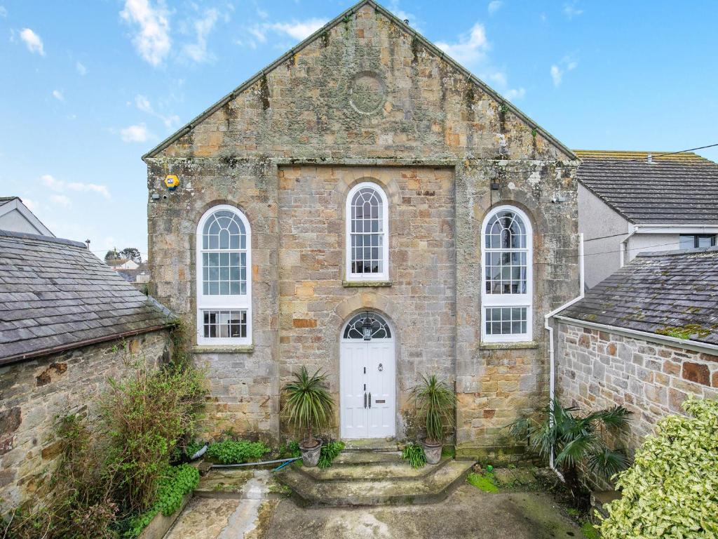 an old brick church with a white door at The Old Chapel in Saint Columb Minor