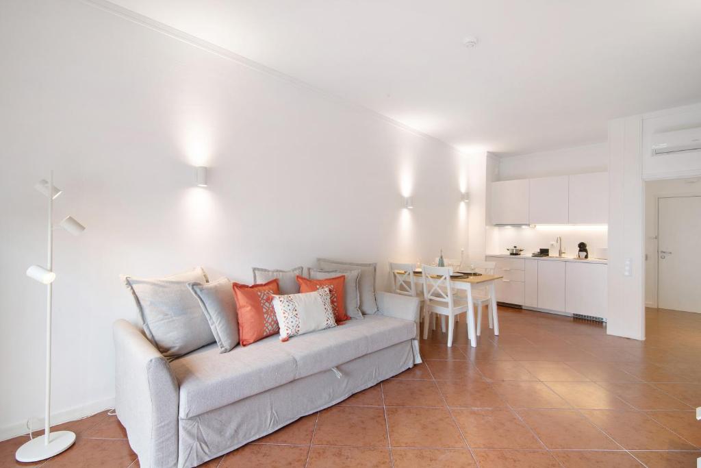 a living room with a couch and a kitchen at Albufeira Haven 103 in Albufeira