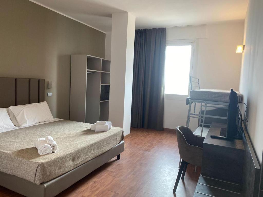 a hotel room with a bed and a desk and a bed at Hotel Golden in Rimini