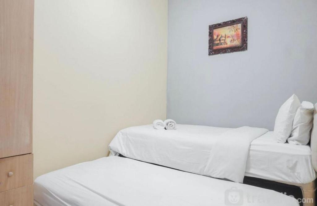 Habitación con 2 camas y una foto en la pared. en casablanca 2, en Yakarta