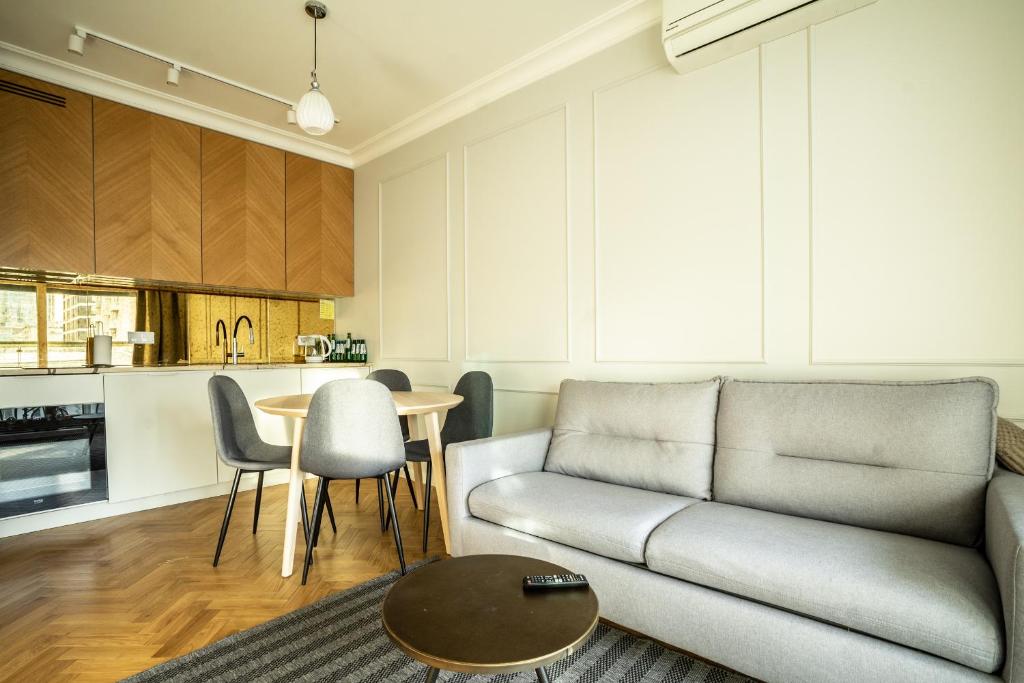 a living room with a couch and a table at VipWarsawApartments Cytryn Mennica Residence in Warsaw