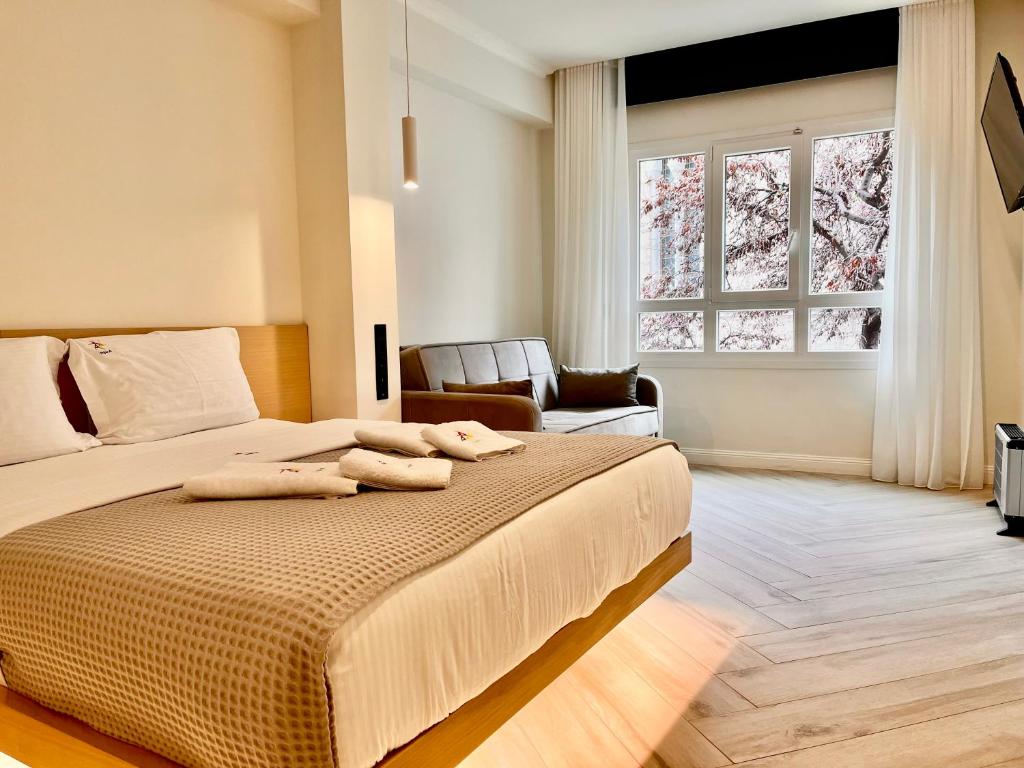 una camera da letto con un letto e due asciugamani di Triple A - Stylish Seven On The Pedestrian - FREE Parking! ad Atene