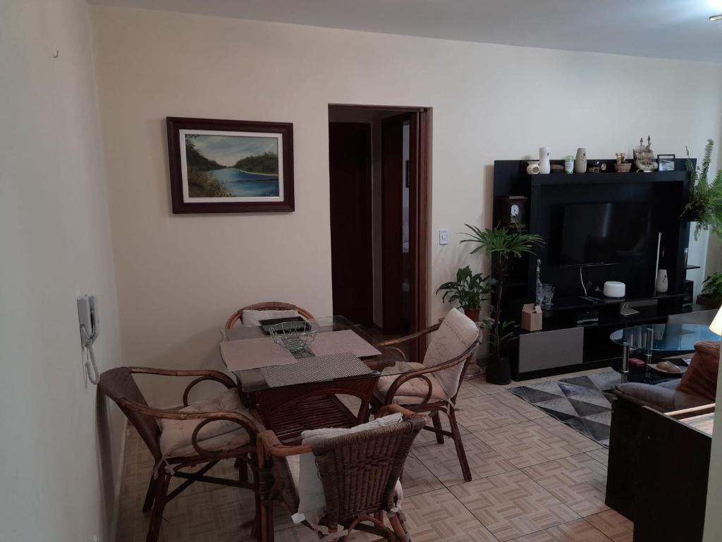 a living room with a table and chairs and a television at Condominio Binacional in Santana do Livramento