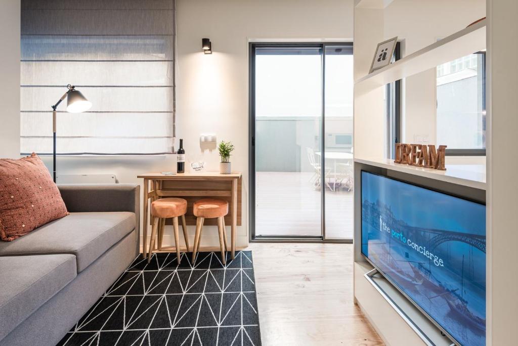 a living room with a couch and a tv at GuestReady - Three Mirrors in Porto