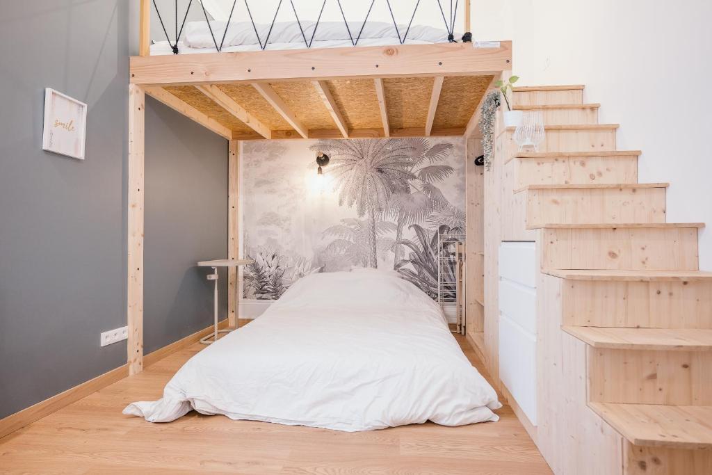 a bedroom with a bed in a room with stairs at Studio Vichy mon amour Villa Marie Celine in Vichy