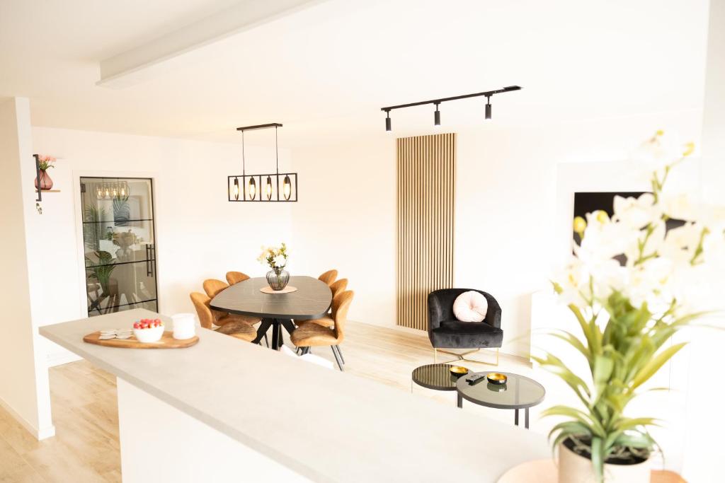uma sala de estar branca com uma mesa e cadeiras em Ostend Centre Bayview Apartment + Free Parking em Oostende