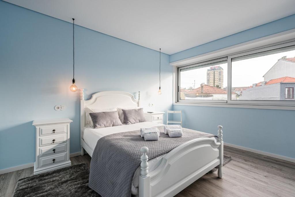 ein Schlafzimmer mit einem weißen Bett und einem Fenster in der Unterkunft GuestReady - Assuntos de recreio in Porto