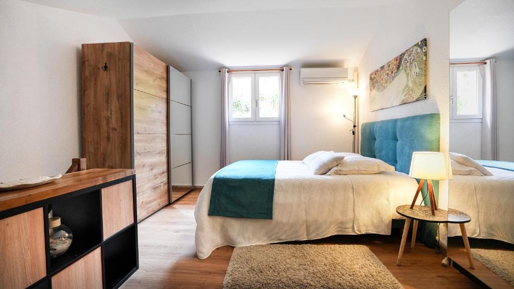 a bedroom with two beds and a table with a lamp at Horizon Vue mer 180° in Saint-Raphaël