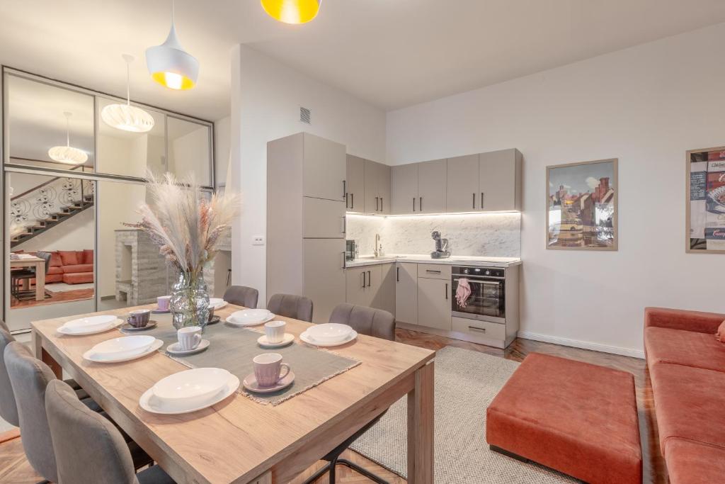 a kitchen and dining room with a table and chairs at Apartament Ultra-Central Premium cu Parcare Gratuita pe Malul Crisului in Oradea