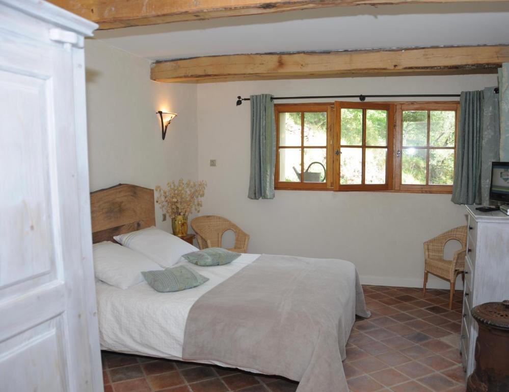 une chambre avec un lit dans une pièce avec une fenêtre dans l'établissement La ferme du Valdeyron, à Valleraugue