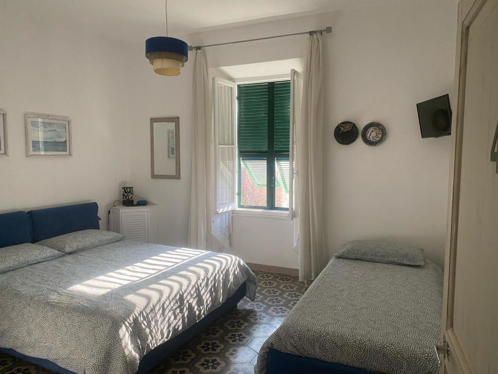 1 dormitorio con 2 camas y ventana en Casa delle farfalle, en Pontinvrea