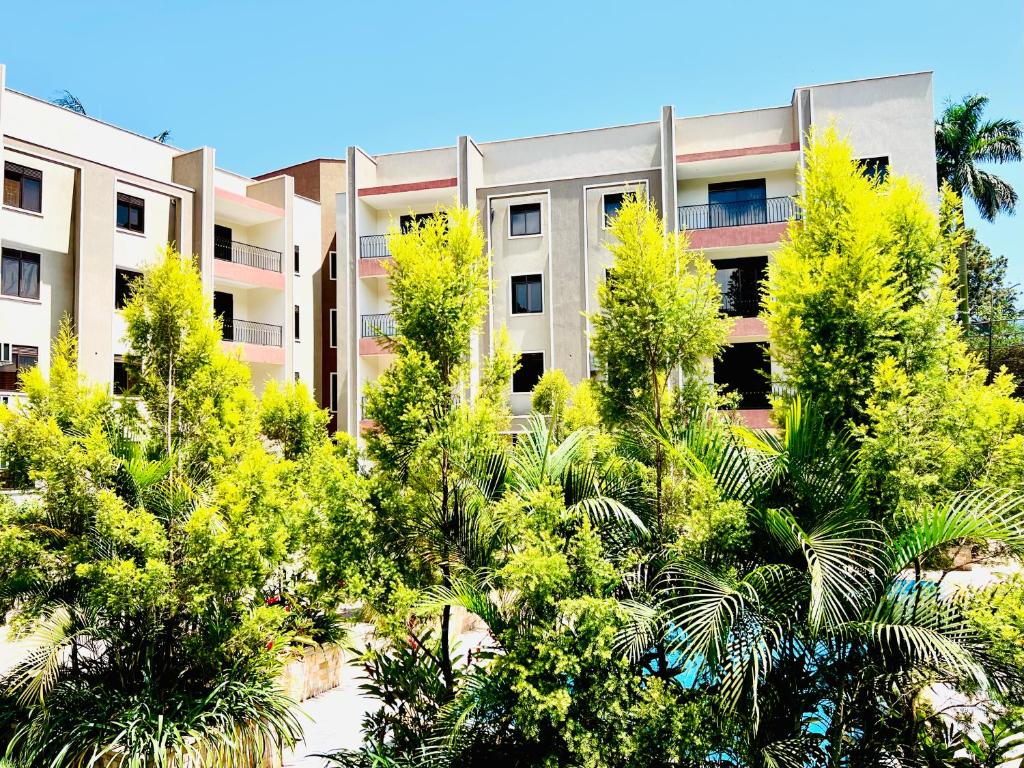 un edificio de apartamentos con árboles delante de él en Julie Heights Apartments en Kampala