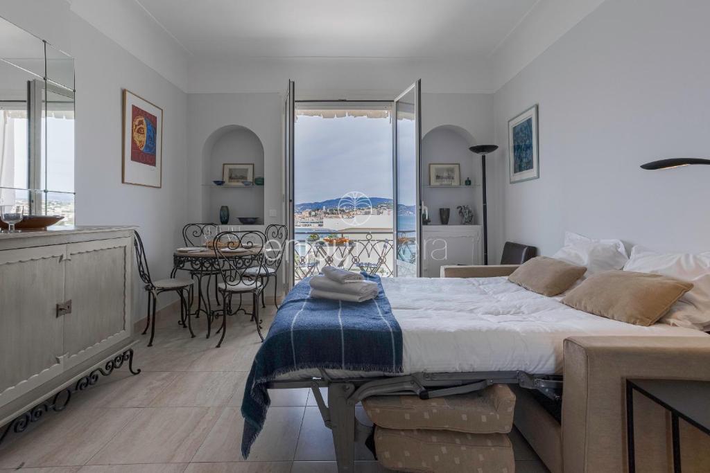 una camera da letto con un letto grande e una sala da pranzo di Palais Miramar - Suite & G17 - Vue Mer - Croisette Emplacement Unique -20 Plage - WIFI - Clim a Cannes