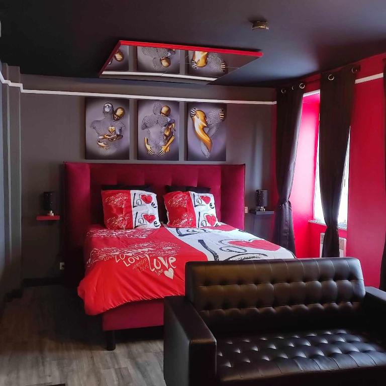 Saint-Pierre-de-PlesguenにあるL'évasion Plaisir Privé SPAのベッドルーム(赤いベッド1台、ソファ付)